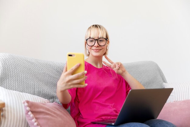 Mooie vrouw die een selfie maakt terwijl ze thuis werkt