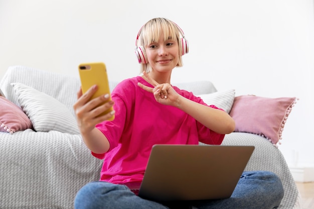 Mooie vrouw die een selfie maakt terwijl ze thuis werkt