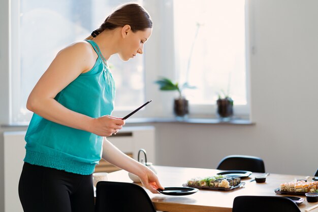 Mooie vrouw die een sushipartij voorbereidt voor haar vrienden