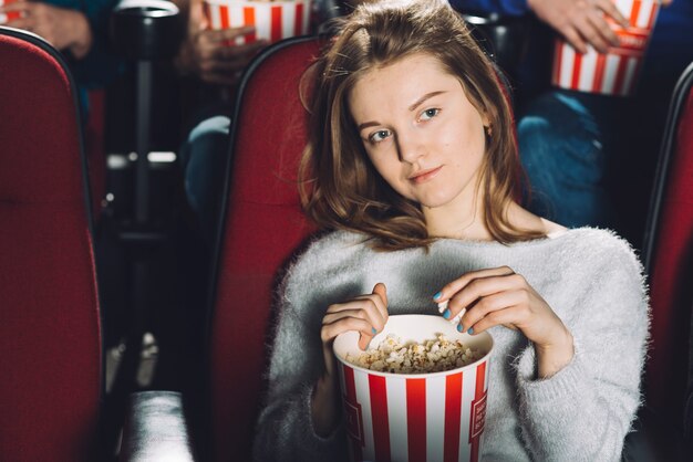 Mooie vrouw die film in bioskoop letten