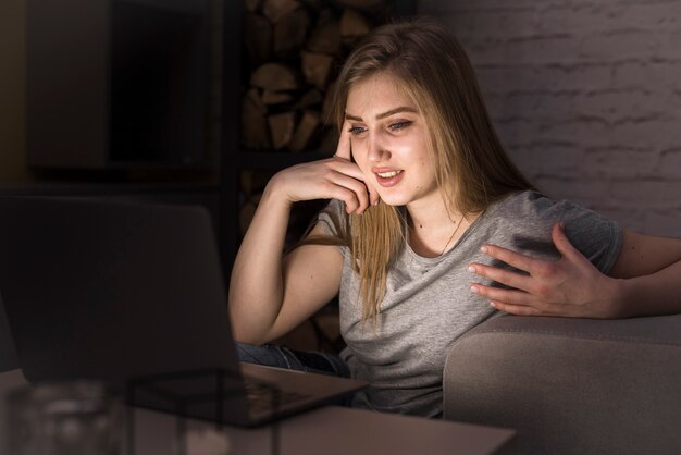 Mooie vrouw die in haar laptop kijkt