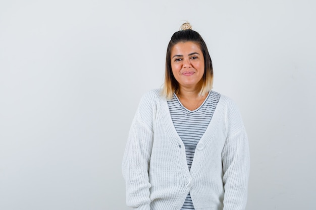 Mooie vrouw die naar de camera kijkt in t-shirt, vest en er vrolijk uitziet