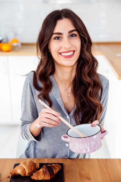 Mooie vrouw die ontbijt voorbereidt