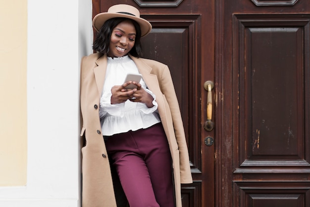 Gratis foto mooie vrouw die op haar telefoon met exemplaarruimte kijkt