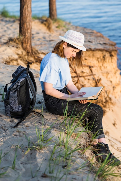 Mooie vrouw die op klif leest