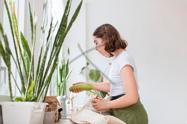 Mooie vrouw die organische boodschappen schikt