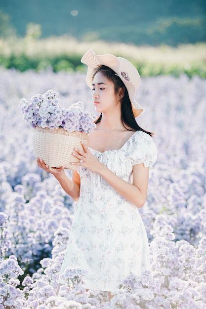 Mooie vrouw die van bloemengebied geniet