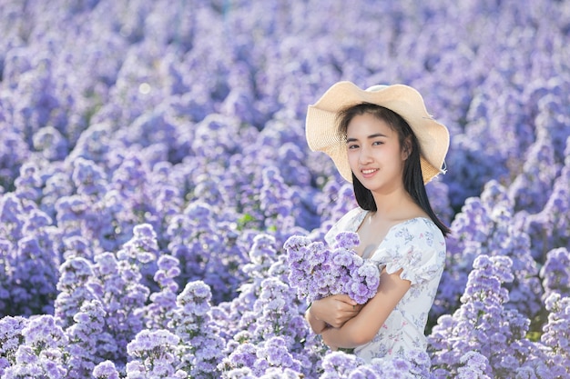 Mooie vrouw die van bloemengebied geniet