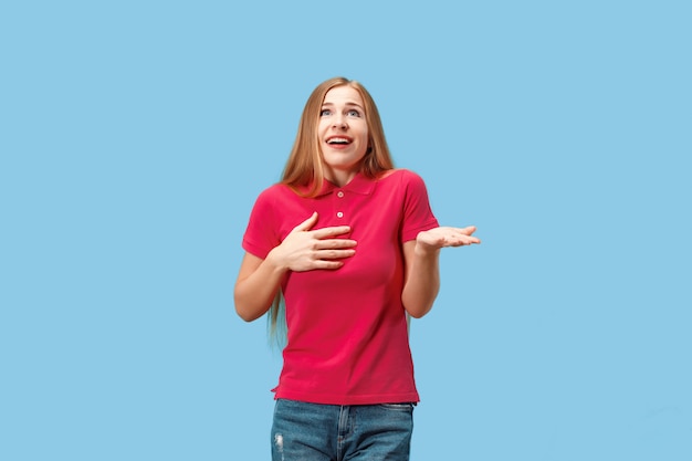 Mooie vrouw die verrast kijkt geïsoleerd op blauw