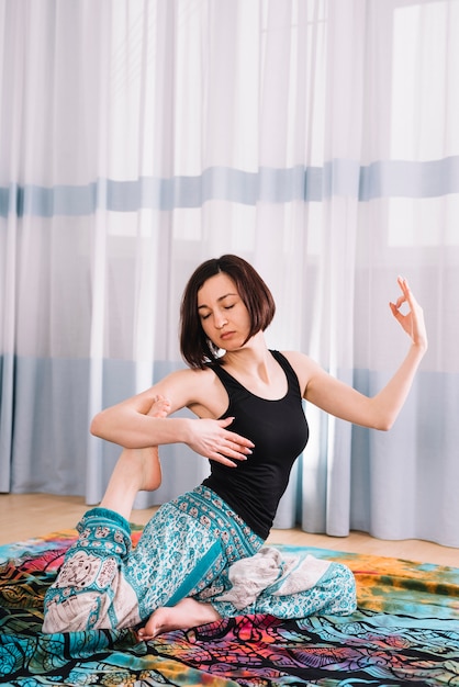 Mooie vrouw die yoga met mudragebaar doet op geschiktheidscentrum