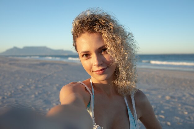 Mooie vrouw die zich op het strand bevindt