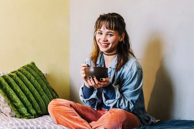 Mooie vrouw eten op bed