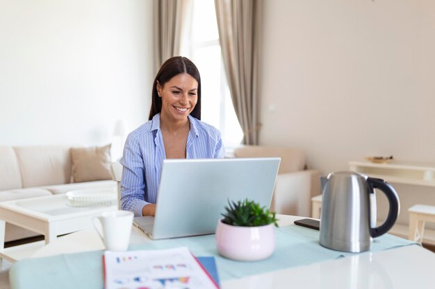 Mooie vrouw freelancer die informatie opmerkt voor het plannen van een project op afstand via een laptopcomputer Meisje lacht terwijl ze e-mail leest op een modern laptopapparaat