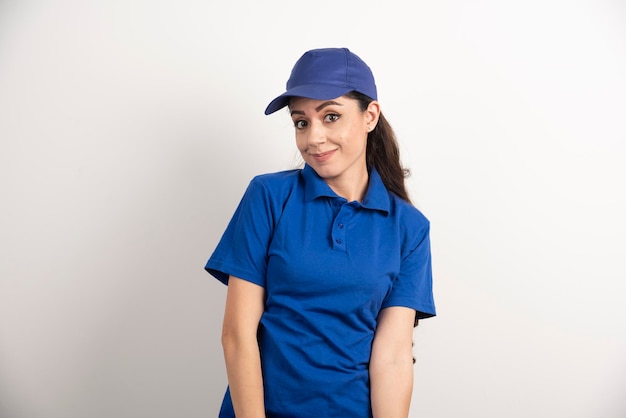 Mooie vrouw in blauw uniform raakt haar gezicht met de hand aan. Hoge kwaliteit foto