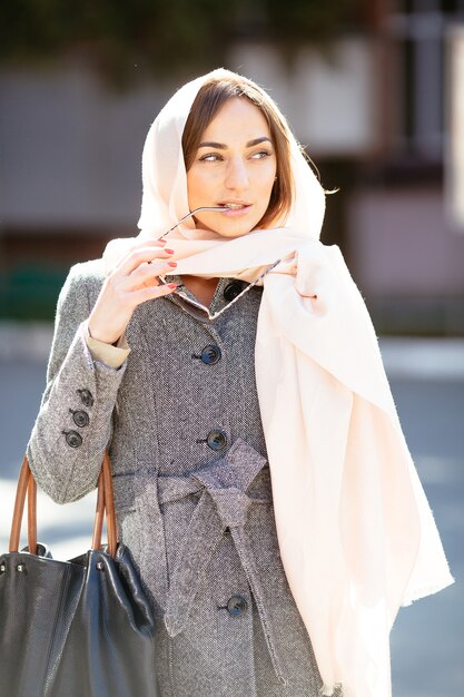 Mooie vrouw in een jas die zich voordeed op straat