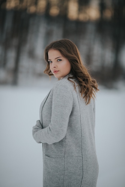 Mooie vrouw in een winter besneeuwd bos