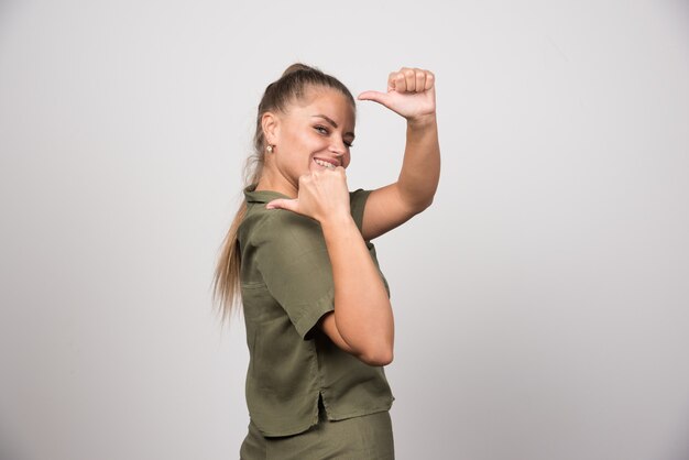 Mooie vrouw in groene jas die iemand belt.