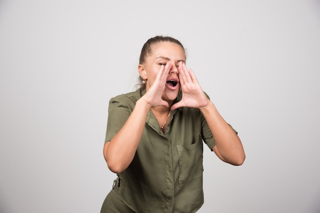 Mooie vrouw in groene jas die iemand belt.