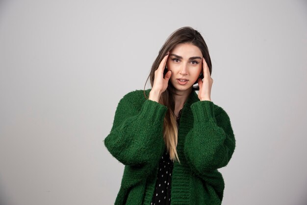 Mooie vrouw in groene trui poseren voor de camera.