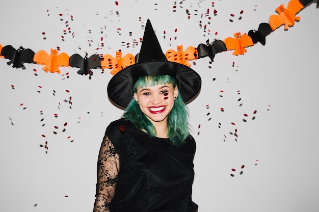 Mooie vrouw in Halloween hoed met confetti