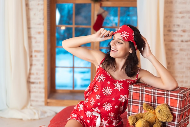 Mooie vrouw in pyjama met geschenkdoos