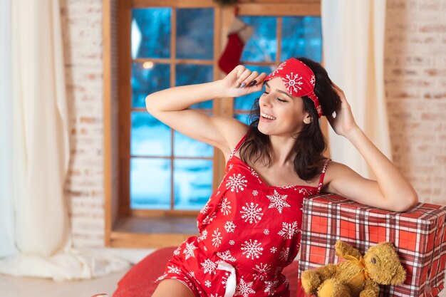 Mooie vrouw in pyjama met geschenkdoos