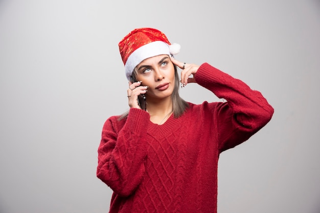 Mooie vrouw in rode trui praten op mobiele telefoon.