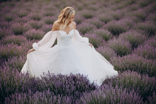 Gratis foto mooie vrouw in trouwjurk in lavendelveld