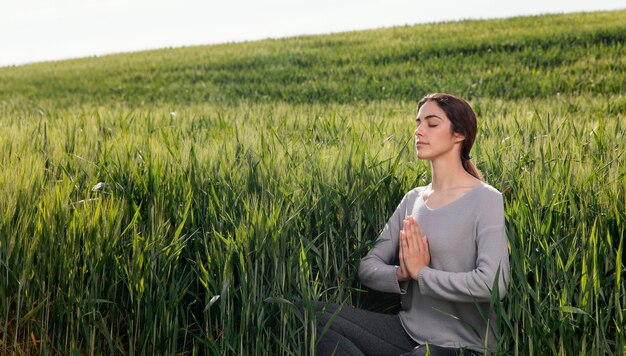 Mooie vrouw mediteren in de natuur