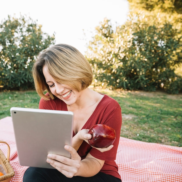 Gratis foto mooie vrouw met apple browsing tablet