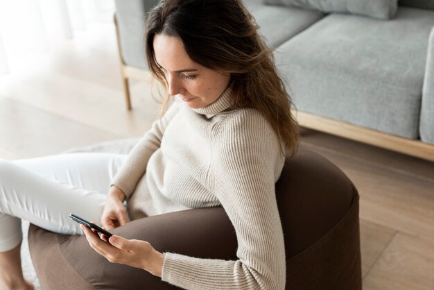 Mooie vrouw met behulp van smartphone op een bank