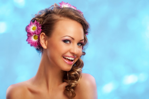 Gratis foto mooie vrouw met bloemen in haar haar