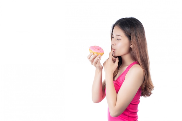 Mooie vrouw met een gelukkige glimlach die een handdoughnut houdt, die op witte achtergrond wordt geïsoleerd.