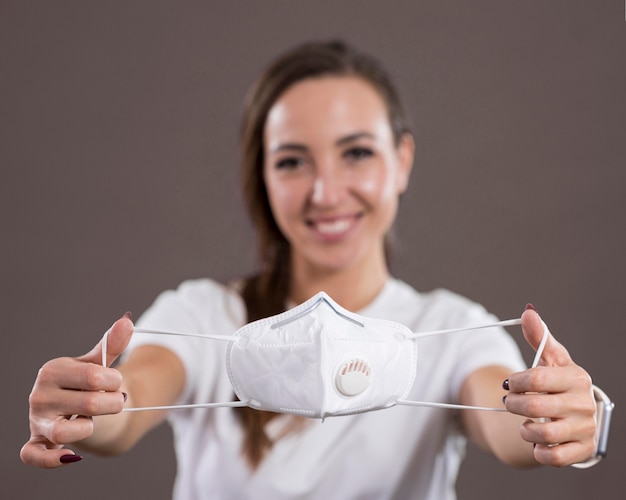 Gratis foto mooie vrouw met gezichtsmasker in studio