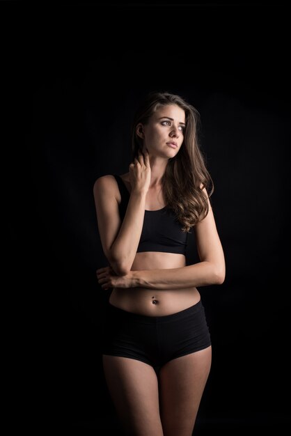 Mooie vrouw met gezond lichaam op zwarte achtergrond