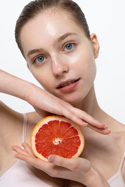 Gratis foto mooie vrouw met grapefruit vooraanzicht