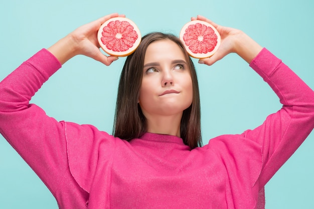 Mooie vrouw met heerlijke grapefruit in haar armen