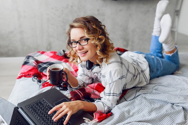 Mooie vrouw met kop koffie en laptop