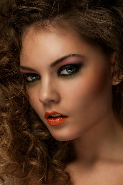 Gratis foto mooie vrouw met krullen en make-up