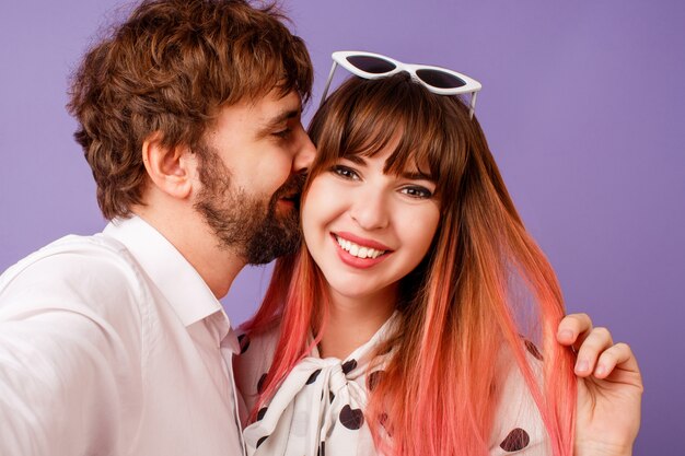 Mooie vrouw met openhartige glimlach en roze haar poseren met haar vriendje met baard