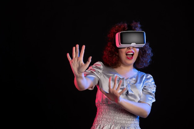 Mooie vrouw met virtual reality headset op donkere ondergrond