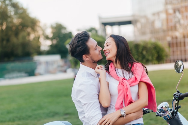 Mooie vrouw met zwart haar man speels zoenen in goede zomerdag op natuur achtergrond