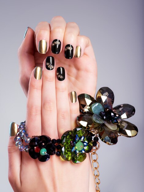 Mooie vrouw nagels met creatieve manicure en sieraden