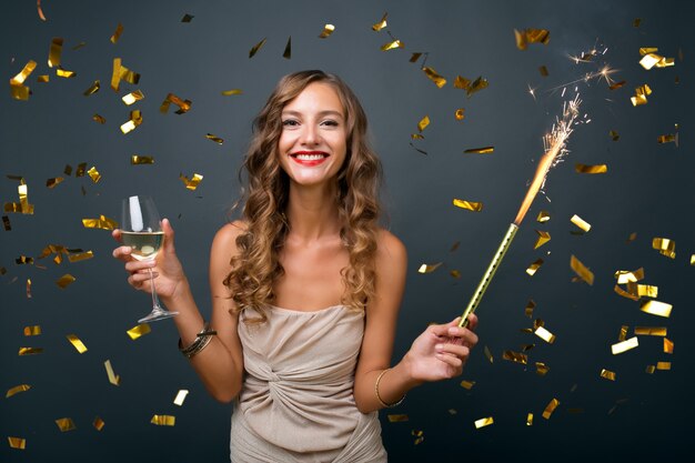 Mooie vrouw Nieuwjaar vieren in gouden confetti