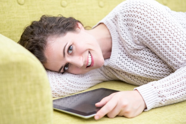 Mooie vrouw op de bank met tablet laten