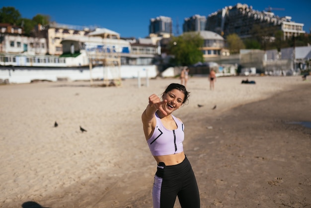 Mooie vrouw op een openbaar strand na training met sportieve look