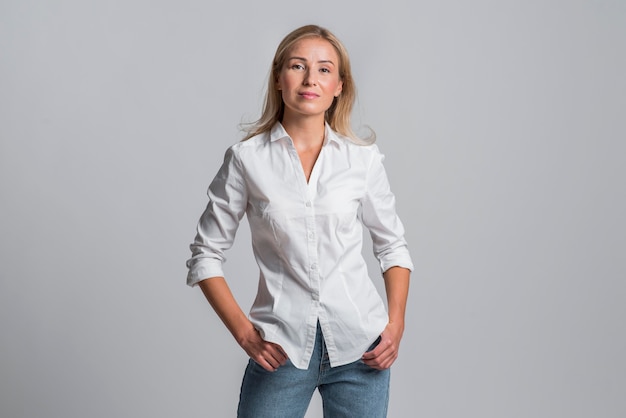 Gratis foto mooie vrouw poseren poseren in jeans en shirt