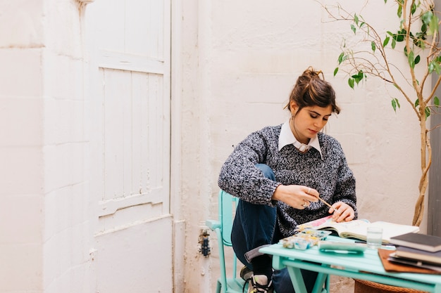 Gratis foto mooie vrouw schilderij in schetsboek