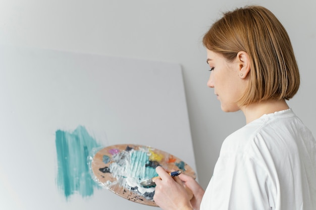 Gratis foto mooie vrouw schilderij met acrylverf op canvas