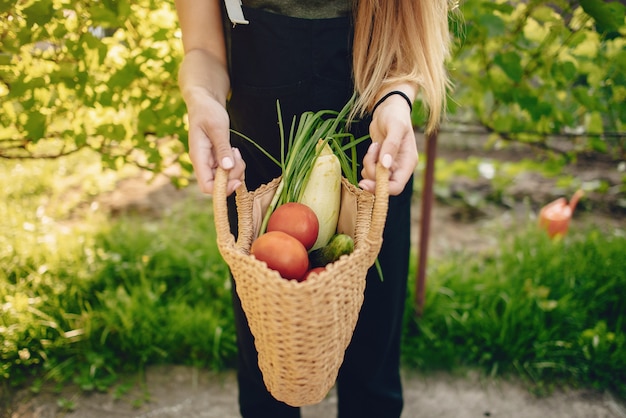 Mooie vrouw werkt in een tuin in de buurt van het huis